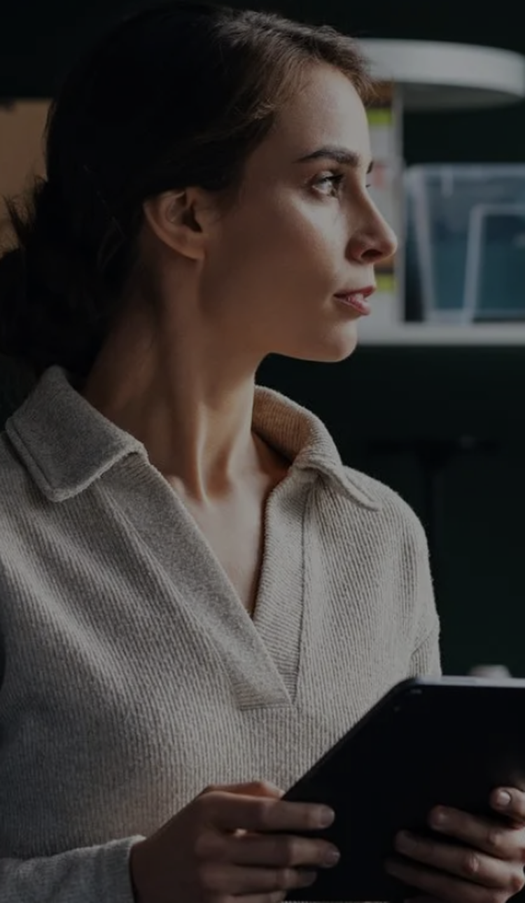 Business customer holding a tablet in front of office shelving.